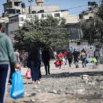 Palestinians carry some of their belongings in Beit Hanun in the northern Gaza Strip, as they flee to a safer location as their area are being bombed frequently by Israeli air strike.